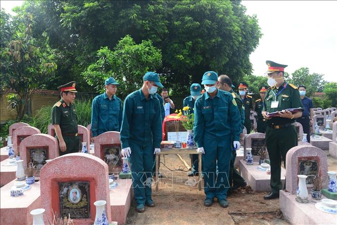 Khai quật, đưa hài cốt liệt sĩ chưa xác định danh tính về khu vực lấy mẫu sinh phẩm tại Nghĩa trang liệt sĩ Yên Viên (xã Phù Đổng, Hà Nội). Ảnh: TTXVN phát
