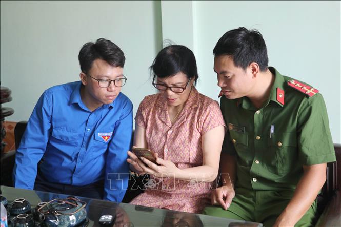 Lực lượng công an cùng với đoàn viên thanh niên hỗ trợ người dân tiếp cận các nền tảng số tại xã Giao Bình, tỉnh Ninh Bình. Ảnh: Thùy Dung - TTXVN