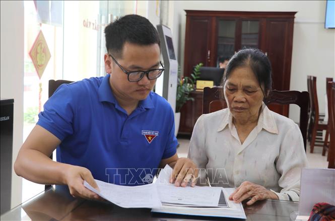 Đoàn viên thanh niên hướng dẫn người dân sử dụng dịch vụ công trực tuyến tại Trung tâm Phục vụ hành chính công xã Giao Bình, tỉnh Ninh Bình. Ảnh: Thùy Dung - TTXVN