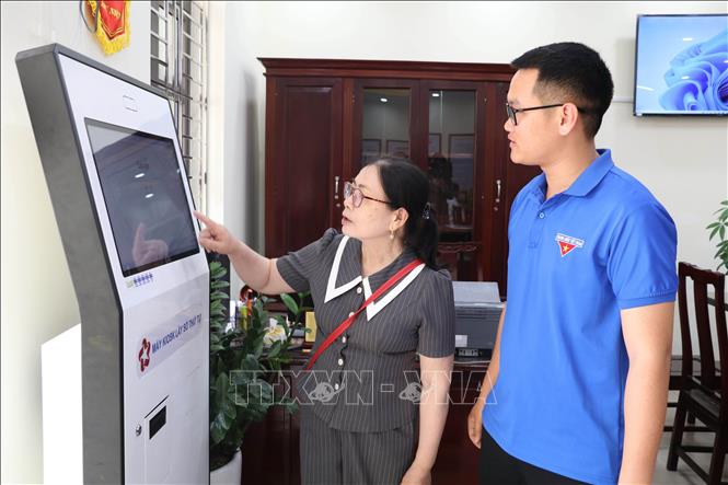 Đoàn viên thanh niên hướng dẫn người dân sử dụng dịch vụ công trực tuyến tại Trung tâm Phục vụ hành chính công xã Giao Bình, tỉnh Ninh Bình. Ảnh: Thùy Dung - TTXVN