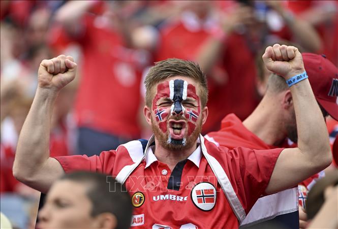 World Cup 2026 đã đi được nửa chặng đường. Những người yêu thích môn túc cầu đã được hòa mình vào bầu không khí sôi động, ngập tràn cảm xúc của ngày hội bóng đá lớn nhất hành tinh, trong đó có những khoảnh khắc ấn tượng, đặc biệt là hình ảnh về cổ động viên. Ảnh: Cổ động viên Na Uy cổ vũ đội nhà. Ảnh: THX/TTXVN phát