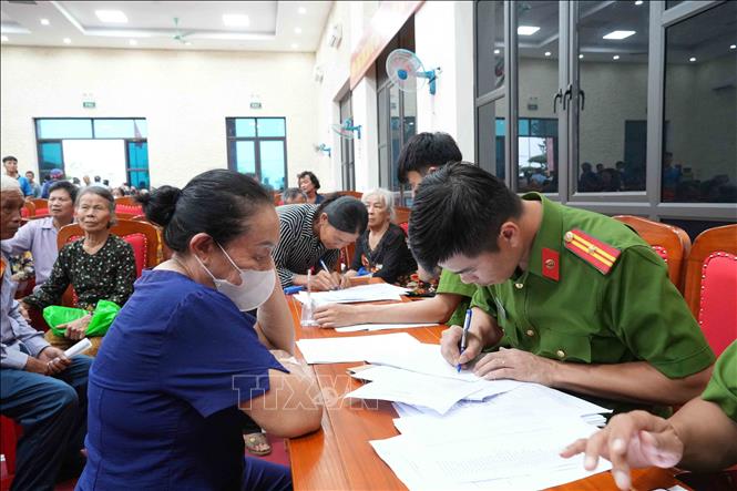 Lực lượng công an và các đoàn thể phối hợp hỗ trợ thân nhân liệt sĩ trong ngày đầu triển khai thu nhận mẫu ADN. Ảnh: Hữu Quyết - TTXVN