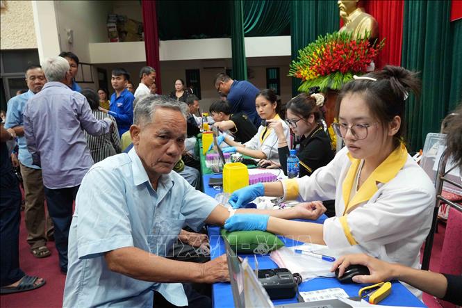 Cán bộ chuyên môn thực hiện thu nhận mẫu sinh phẩm ADN của thân nhân liệt sĩ theo đúng quy trình. Ảnh: Hữu Quyết - TTXVN