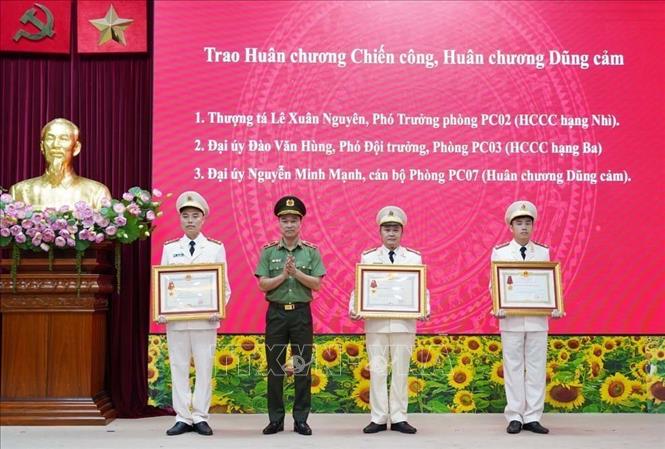 Thừa ủy quyền, Thiếu tướng Tô Anh Dũng, Giám đốc Công an tỉnh trao Huân chương Chiến công, Huân chương Dũng cảm cho 3 cá nhân. Ảnh: TTXVN phát
