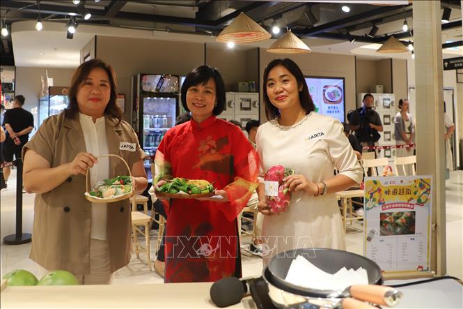 Bà Lê Đức Hạnh, Tổng Lãnh sự Việt Nam tại Hong Kong (Trung Quốc) và bà Vũ Thị Thúy, Phó Tổng lãnh sự, Trưởng Thương vụ Việt Nam tại Hong Kong cùng đại diện Ban lãnh đạo của hệ thống siêu thị APITA Hong Kong tại gian hàng đồ ăn Việt. Ảnh: Trần Thị Lê Anh - PV TTXVN tại Hong Kong