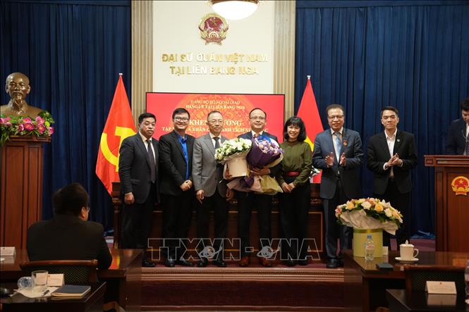 Đại sứ Đặng Minh Khôi cùng một số đại biểu tặng hoa chúc mừng và chụp ảnh lưu niệm cùng ông Đỗ Xuân Hoàng, Chủ tịch Hội Người Việt Nam tại LB Nga. Ảnh: Trần Hải - PV TTXVN tại Nga