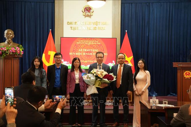 Đại diện các phòng chức năng của Đại sứ quán, Ban cán sự Đoàn, Hội sinh viên và Liên hiệp các tổ chức người Việt Nam tại Nga tặng hoa chúc mừng Đại sứ Đặng Minh Khôi. Ảnh: Trần Hải - PV TTXVN tại Nga