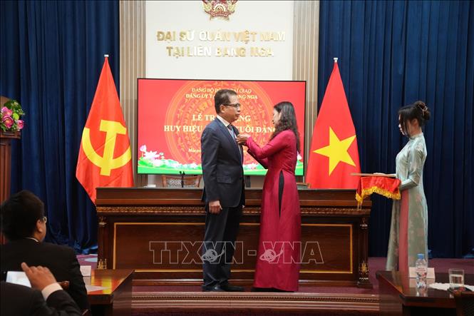 Phó Bí thư Đảng ủy tại Liên bang Nga Ngô Thị Thu Hoài gắn, trao huy hiệu 30 năm tuổi Đảng cho Đại sứ Việt Nam tại Nga Đặng Minh Khôi. Ảnh: Trần Hải - PV TTXVN tại Nga
