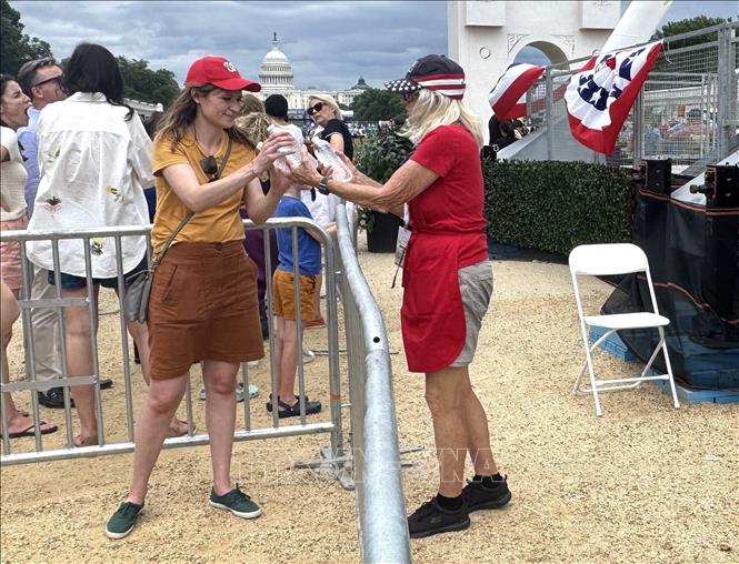 Tình nguyện viên phát nước uống miễn phí cho người dân tham dự Lễ hội Great American State Fair tại Washington D.C. nhằm giảm nguy cơ say nắng trong điều kiện thời tiết nắng nóng cực đoan. Ảnh: Đoàn Hùng - P/v TTXVN tại Mỹ