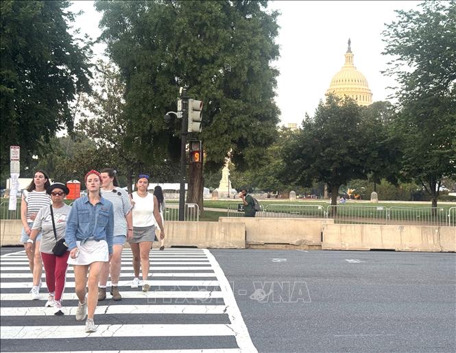 Người dân di chuyển quanh khu vực National Mall, Washington D.C trong bối cảnh đợt nắng nóng cực đoan đã buộc ban tổ chức điều chỉnh lịch nhiều hoạt động kỷ niệm 250 năm Quốc khánh Mỹ và hủy cuộc diễn hành dự kiến diễn ra ngày 4/7. Ảnh: Đoàn Hùng - P/v TTXVN tại Mỹ