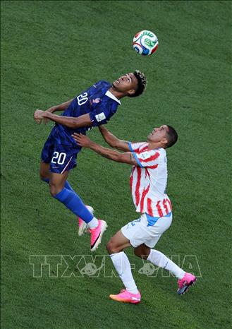 Pha tranh bóng giữa Desire Doue (trái) của Pháp và cầu thủ Paraguay. Ảnh: THX/TTXVN phát