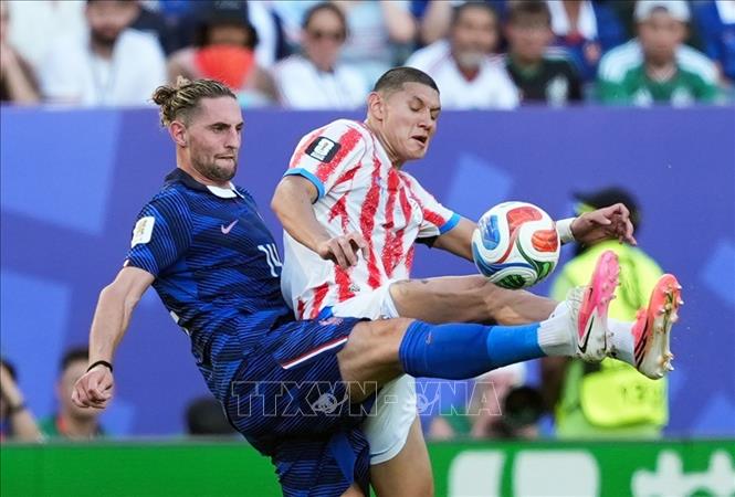 Pha tranh chấp bóng giữa Adrien Rabiot (trái) của Pháp và Juan Jose Caceres của Paraguay. Ảnh: THX/TTXVN phát