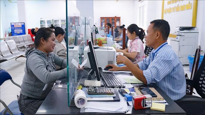 Cán bộ tại Trung tâm Phục vụ hành chính công phường Tân Ninh hướng dẫn người dân thực hiện thủ tục hành chính trên môi trường số. Ảnh: Minh Phú - TTXVN