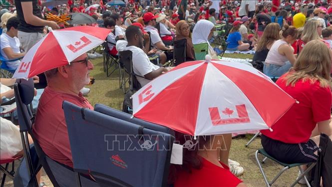 Hai cổ đông viên trong những chiếc nón mang hình cờ Canada, góp phần tạo nên bầu không khí náo nhiệt trước trận đấu. Ảnh: Hà Linh - PV TTXVN tại Canada