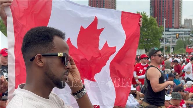 Cổ động viên Canada trong trang phục áo đấu và cờ tổ chức đang tạo nên không khí lễ hội trước trận đấu ở khu FanZone Ottawa. Ảnh: Hà Linh - PV TTXVN tại Canada
