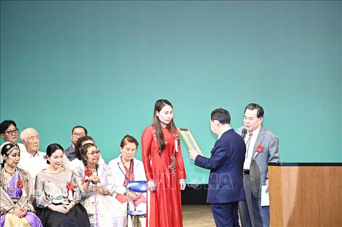 Đại diện Tổ chức xúc tiến hữu nghị quốc tế đọc quyết định trao thưởng cho bà Lê Thương. Ảnh: Nguyễn Tuyến - Pv TTXVN tại Nhật Bản