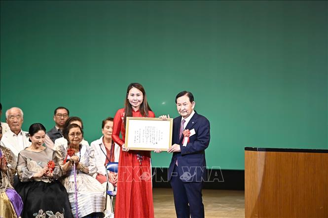 Bà Lê Thương, Chủ tịch Hiệp hội Người Việt Nam vùng Kansai, nhận “Giải thương cộng đồng cho công dân toàn cầu” do IHA trao tặng. Ảnh: Nguyễn Tuyến - Pv TTXVN tại Nhật Bản