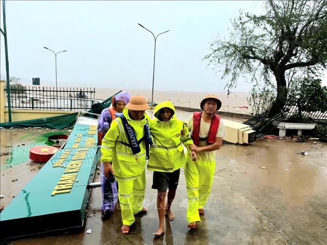 Các thuyền viên được lực lượng chức năng hỗ trợ đưa vào đất liền an toàn. Ảnh: TTXVN phát