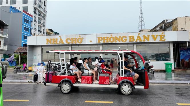 Các du khách đi xe điện ra cảng tàu để lên tàu trở về đất liền. Ảnh: Thu Báu/TTXVN phát