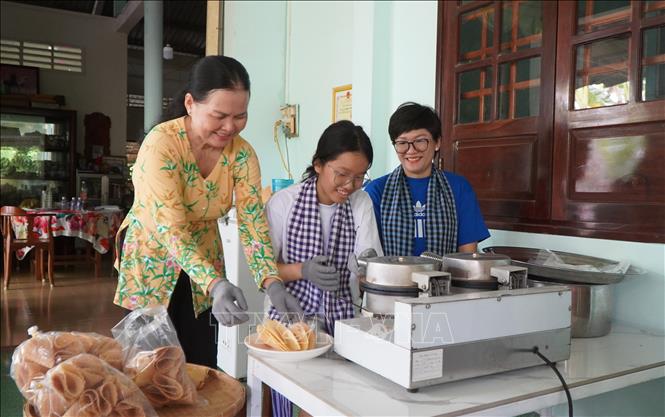 Du khách trải nghiệm làm bánh kẹp xoài. Ảnh: Nhựt An - TTXVN