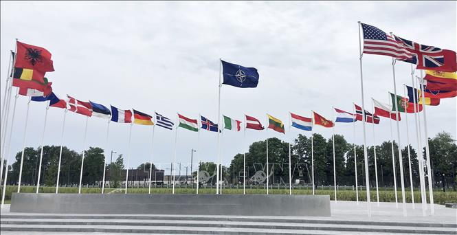 Cờ NATO và quốc kỳ các nước thành viên bên ngoài trụ sở liên minh quân sự ở Brussels, Bỉ. Ảnh: AA, Kyodo/TTXVN phát