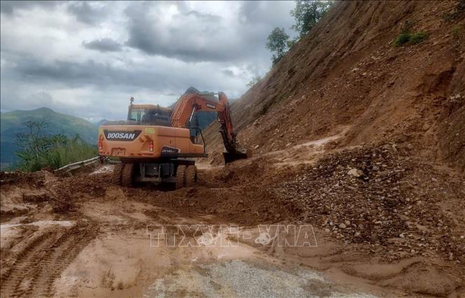 Đơn vị thi công huy động máy xúc khắc phục điểm sạt lở taluy dương tại Km 22+200 thuộc Tỉnh lộ 144. Ảnh: TTXVN phát