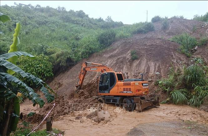 Đơn vị thi công huy động máy xúc khắc phục điểm sạt lở taluy dương tại Km 0+960 trên tuyến đường Huổi Só - Huổi Lóng. Ảnh: TTXVN phát