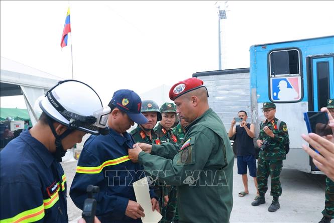Trung tá Raúl Serrano Chacón trao huy chương cho thành viên đoàn Việt Nam. Ảnh: Phi Hùng - PV TTXVN tại Venezuela