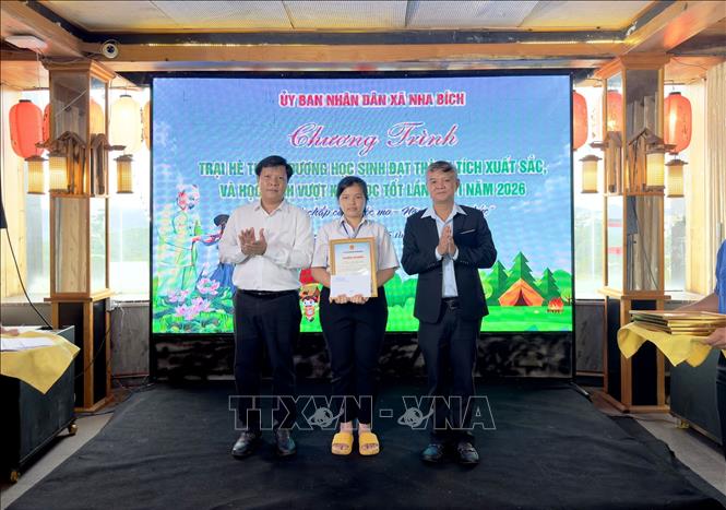 Đại diện lãnh đạo UBND xã Nha Bích tuyên dương các em học sinh có thành tích xuất sắc trong học tập. Ảnh: Đậu Tất Thành – TTXVN.