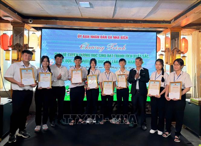Đại diện lãnh đạo UBND xã Nha Bích tuyên dương các em học sinh có thành tích xuất sắc trong học tập. Ảnh: Đậu Tất Thành – TTXVN.