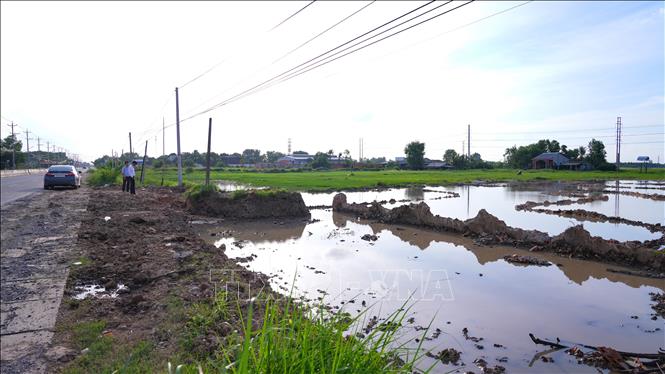 Khu vực nền và đất nông nghiệp xuất hiện nhiều hố đào chứa nước sau khi đất được lấy đi, làm thay đổi hiện trạng mặt bằng. Ảnh: Minh Phú - TTXVN