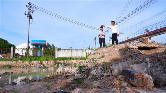 Đại diện chính quyền địa phương ghi nhận hiện trạng khu vực có dấu hiệu khai thác đất, tạo thành các hố sâu tại Dự án đường cao tốc Thành phố Hồ Chí Minh - Mộc Bài. Ảnh: Minh Phú – TTXVN