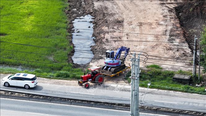 Máy đào cùng các xe công nông vận chuyển đất rời khỏi hiện trường sau khi biết phóng viên ghi nhận hoạt động tại khu vực. Ảnh: Minh Phú – TTXVN