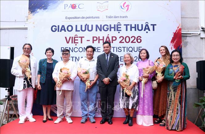 Ông Etienne Ranaivoson, Tổng Lãnh sự Cộng hòa Pháp tại Thành phố Hồ Chí Minh và bà Nguyễn Ngọc Lan, Viện trưởng Viện Trao đổi văn hóa với Pháp, bà Nguyễn Thị Ngọc Dung, Chủ tịch Hội hữu nghị Việt Nam- Pháp Thành phố Hồ Chí Minh tặng hoa chúc mừng các họa sĩ có tác phẩm trưng bày. Ảnh: Xuân Khu-TTXVN