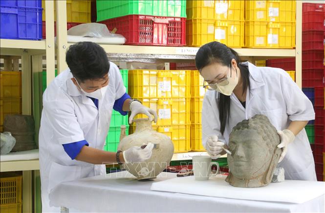 Cán bộ, nhân viên Ban Quản lý Di tích văn hóa Óc Eo (tỉnh An Giang) đang chỉnh lý, sắp xếp lại kho lưu trữ hiện vật đã được khai quật, phục vụ công tác trung bày và quá trình đánh giá của đoàn chuyên gia quốc tế. Ảnh: Công Mạo - TTXVN