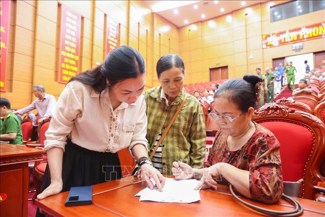 Thân nhân liệt sĩ làm thủ tục đăng ký trước khi thực hiện thu nhận mẫu sinh phẩm ADN tại điểm thu nhận ở xã Yên Phong, tỉnh Bắc Ninh. Ảnh: Tiến Long/TTXVN phát