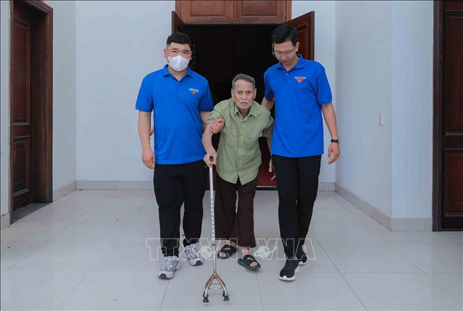 Lực lượng đoàn viên thanh niên xã tích cực đồng hành, hỗ trợ các cụ thân nhân gia đình liệt sĩ trong quá trình di chuyển và thực hiện thủ tục lấy mẫu ADN. Ảnh: Phan Phương-TTXVN