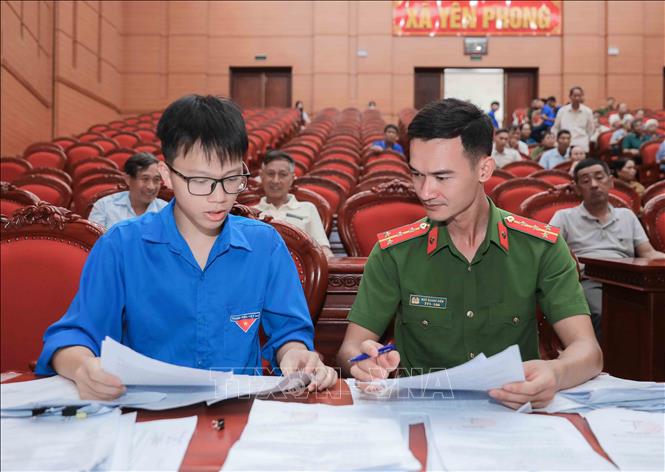 Cán bộ Công an hướng dẫn thân nhân liệt sĩ đối chiếu thông tin, hoàn thiện hồ sơ trước khi lấy mẫu ADN. Ảnh: Tiến Long/TTXVN phát
