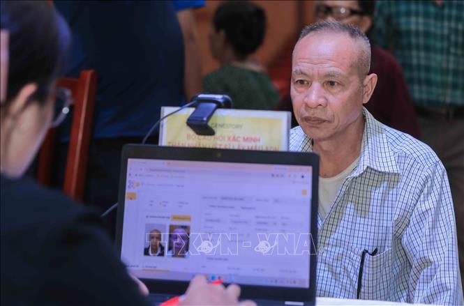 Lực lượng chức năng tiến hành quét khuôn mặt để xác thực thông tin công dân trên hệ thống VNeID, sau đó cập nhật dữ liệu đồng bộ vào hệ thống quản lý của đơn vị Genestory nhằm phục vụ công tác giám định. Ảnh: Phan Phương-TTXVN