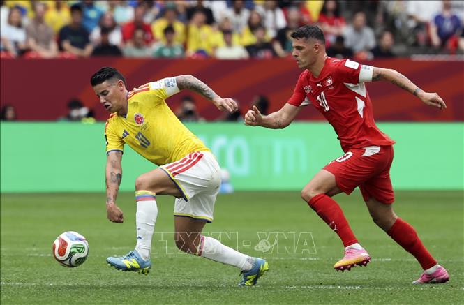 Cầu thủ James Rodriguez (trái) của Colombia đi bóng trước sức ép của cầu thủ Thụy Sĩ. Ảnh: THX/TTXVN phát