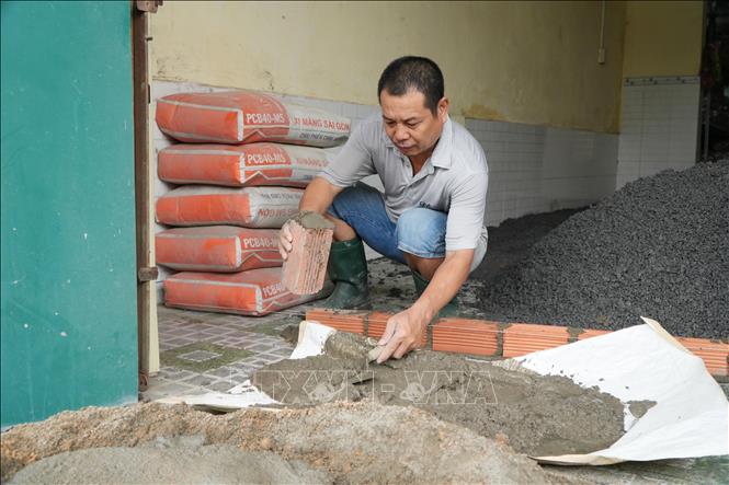 Nhiều người dân đã chủ động sửa lui mặt tiền, bàn giao mặt bằng cho đơn vị thi công, mở rộng đường. Ảnh: Lê Xuân - TTXVN