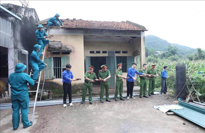 Đoàn viên, thanh niên các đơn vị tu sửa nhà liệt sĩ cho gia đình bà Chu Thị Chứng thôn Nà Lừa, xã Kiên Mộc (là con liệt sĩ Chu Văn Tiên) tại Chương trình. Ảnh: Anh Tuấn – TTXVN