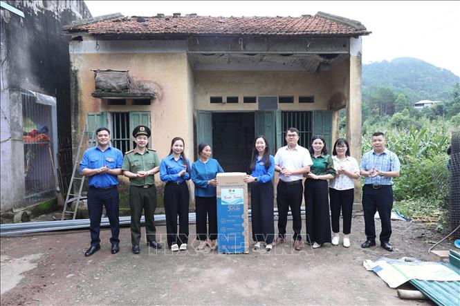 Đại diện các đơn vị tặng máy lọc nước cho gia đình bà Chu Thị Chứng thôn Nà Lừa, xã Kiên Mộc. Ảnh: Anh Tuấn – TTXVN