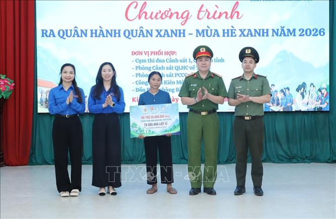 Đại diện các đơn vị trao biểu trưng hỗ trợ 20 triệu đồng tu sửa nhà liệt sĩ cho gia đình bà Chu Thị Chứng thôn Nà Lừa, xã Kiên Mộc (là con liệt sĩ Chu Văn Tiên) tại Chương trình. Ảnh: Anh Tuấn – TTXVN