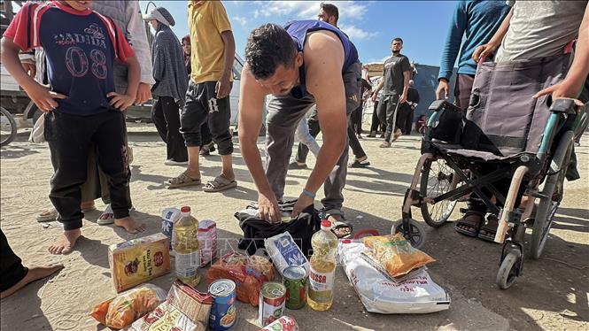 Người dân Palestine nhận hàng cứu trợ tại trung tâm phân phối ở Rafah, Dải Gaza. Ảnh: THX/TTXVN phát