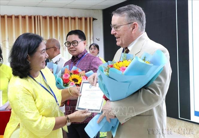 Ban tổ chức tặng hoa cảm ơn các học giả tại Hội thảo khoa học quốc tế “Giáo dục – Đào tạo đáp ứng mục tiêu phát triển bền vững” bằng hình thức trực tiếp và trực tuyến do trường Đại học Trà Vinh phối hợp với trường Đại học Công lập Southern Leyte (Philippines) tổ chức, ngày 14/3/2025. Ảnh: Thanh Hòa - TTXVN