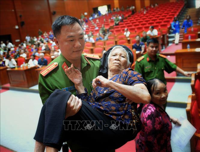 Lực lực lượng công an xã Hoàng Vân hỗ trợ thân nhân liệt sĩ đến thu mẫu phục vụ xác định danh tính liệt sĩ. Ảnh: Danh Lam-TTXVN