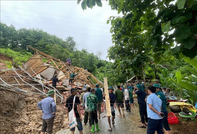 Cán bộ, chiến sĩ lực lượng công an, quân đội và các tổ chức đoàn thể cùng nhân dân xã Mường Sại, tỉnh Sơn La tham gia hỗ trợ gia đình Lò Văn Tuyến di dời tài sản do nhà bị đổ sập gây ra bởi sạt lở taluy dương. Ảnh: TTXVN phát