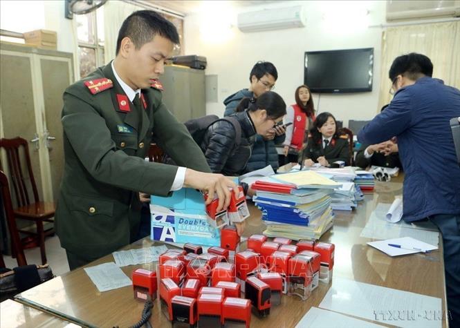 Lực lượng An ninh điều tra kiểm tra số hóa đơn, con dấu và các tang vật của các đối tượng vi phạm trong vụ án Nguyễn Thị Đào cùng đồng phạm mua bán trái phép hóa đơn giá trị gia tăng, xuất khống qua 17 công ty 3.500 hóa đơn với doanh thu trước thuế là 590 tỷ đồng, xảy ra tại Hà Nội, tháng 12/2017. Ảnh: Doãn Tấn – TTXVN