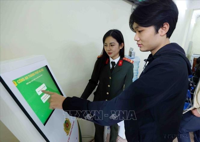 Cán bộ, chiến sĩ Phòng Hồ sơ nghiệp vụ, Công an thành phố Hà Nội hướng dẫn người dân đến làm thủ tục cấp Phiếu lý lịch tư pháp (3/2025). Ảnh: Phạm Kiên – TTXVN
